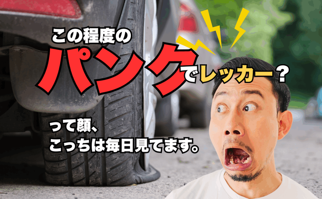 「この程度のパンクでレッカー?」って顔、こっちは毎日見てます。 1 パンクしたタイヤの前でショックを受ける男性とタイトルテキストが入った画像